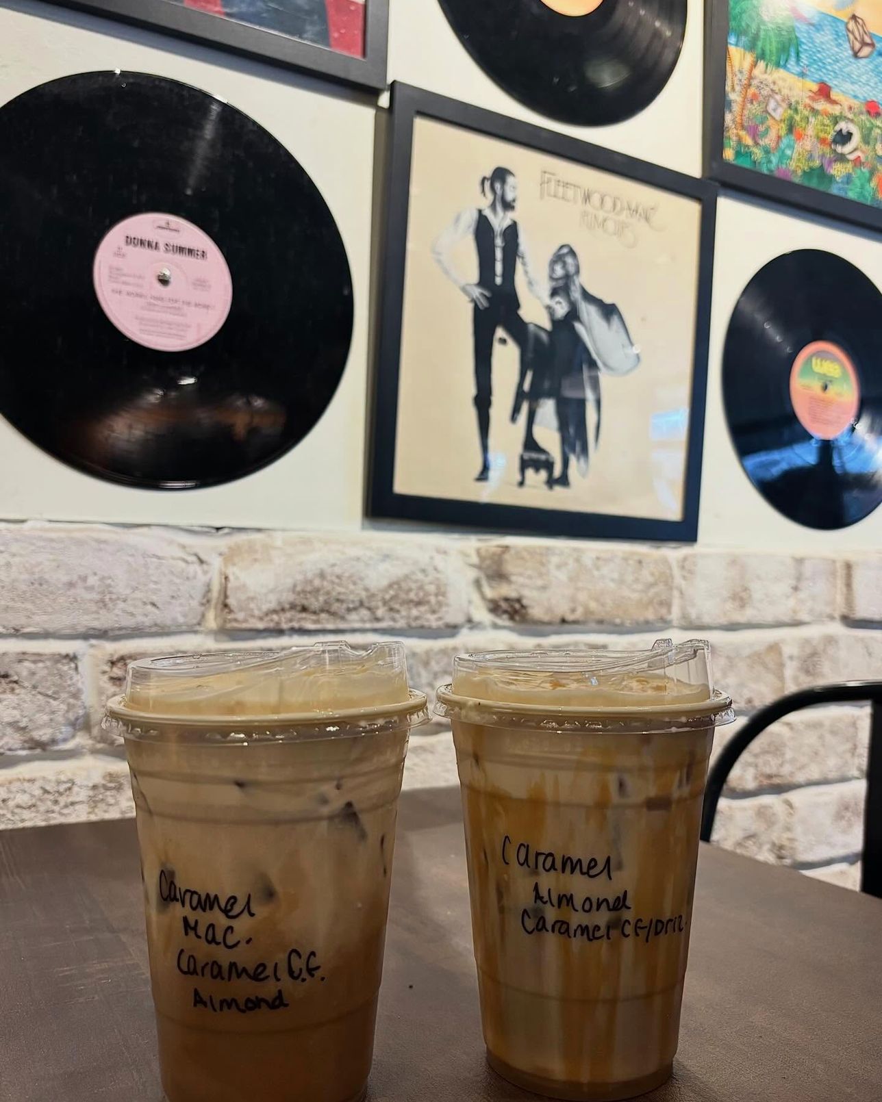 The wall of framed records above the stone wall inside the shop